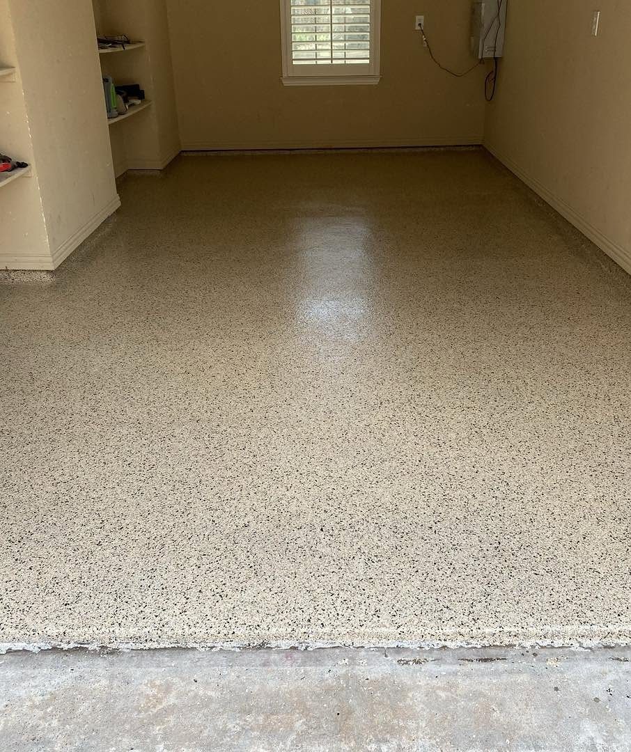 A wide shot of an empty garage featuring a new speckled epoxy floor coating.