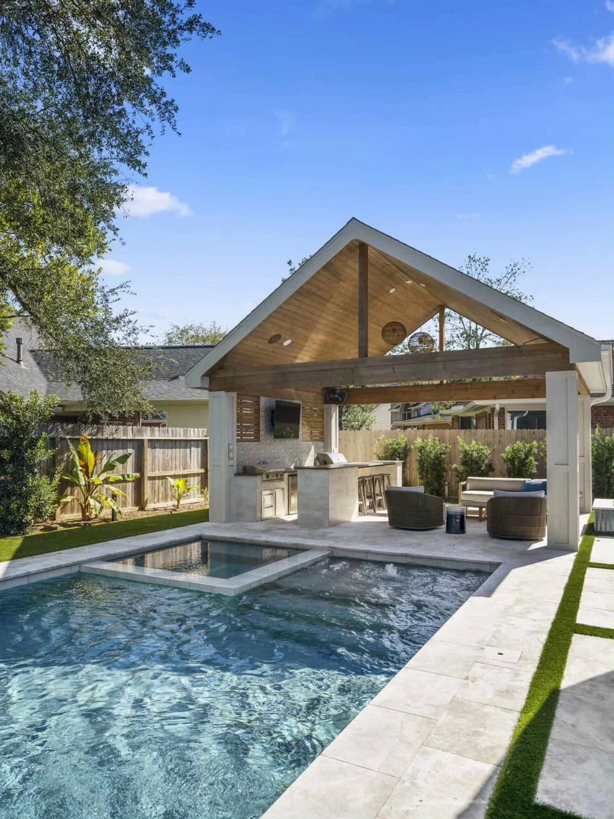 A covered outdoor kitchen station located next to a sparkling blue swimming pool.