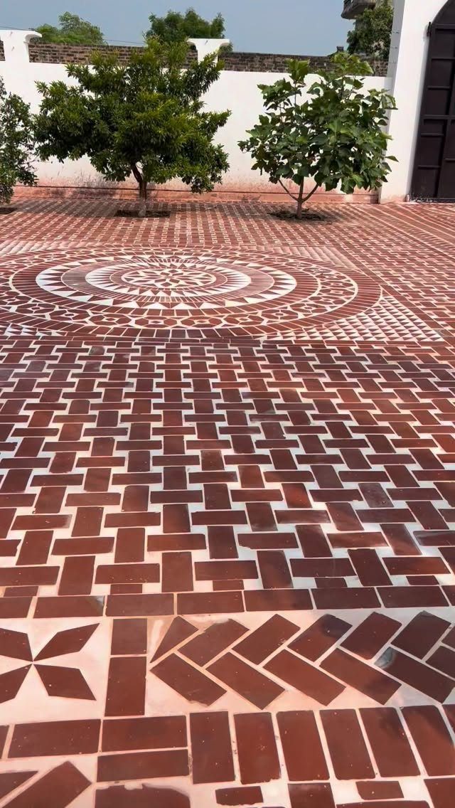 Reddish-brown brick patio featuring intricate circular mandala patterns and various geometric laying styles.