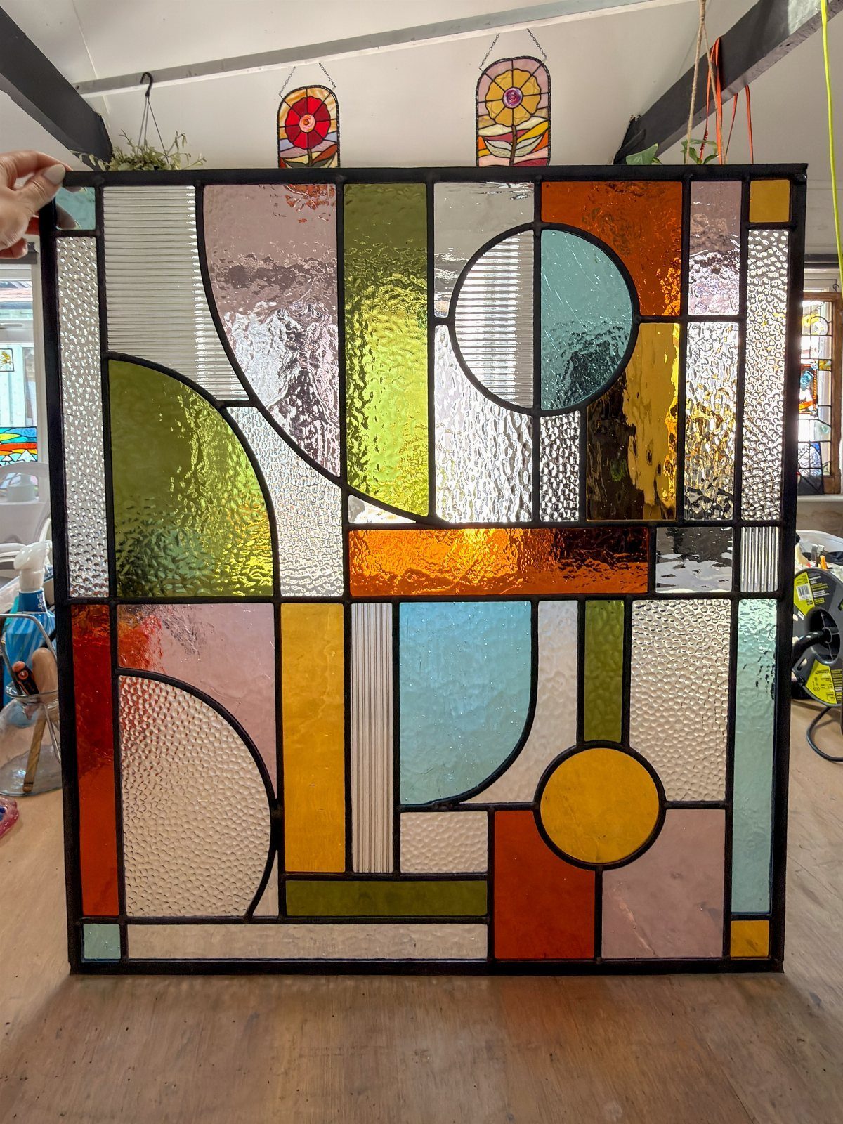 Colorful Stained Glass Design: 10 Ideas to Light a Room 4 Stained glass panel with colorful geometric shapes including circles and rectangles in various textured hues.