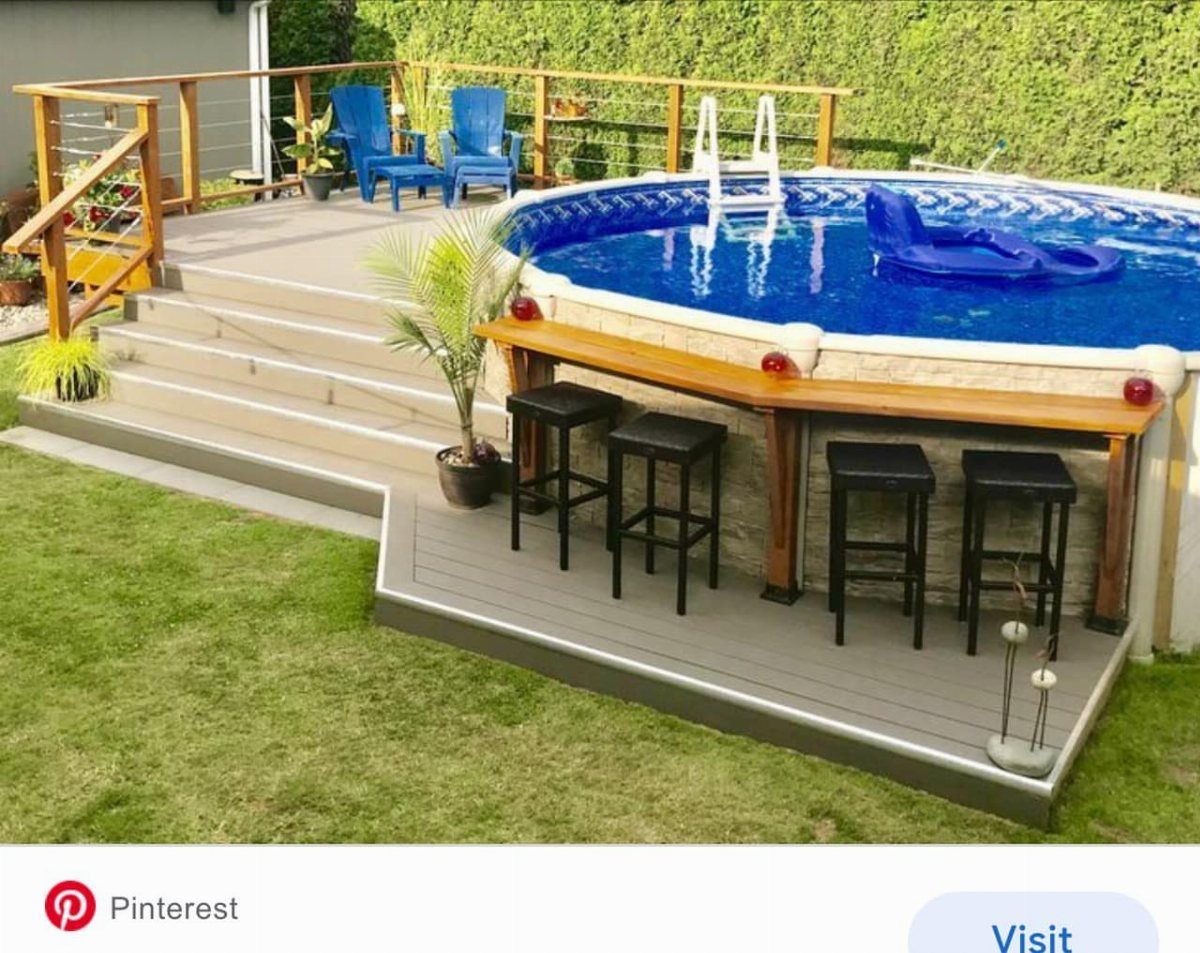 A raised wooden deck with a built-in bar and stools surrounding a blue above-ground pool.