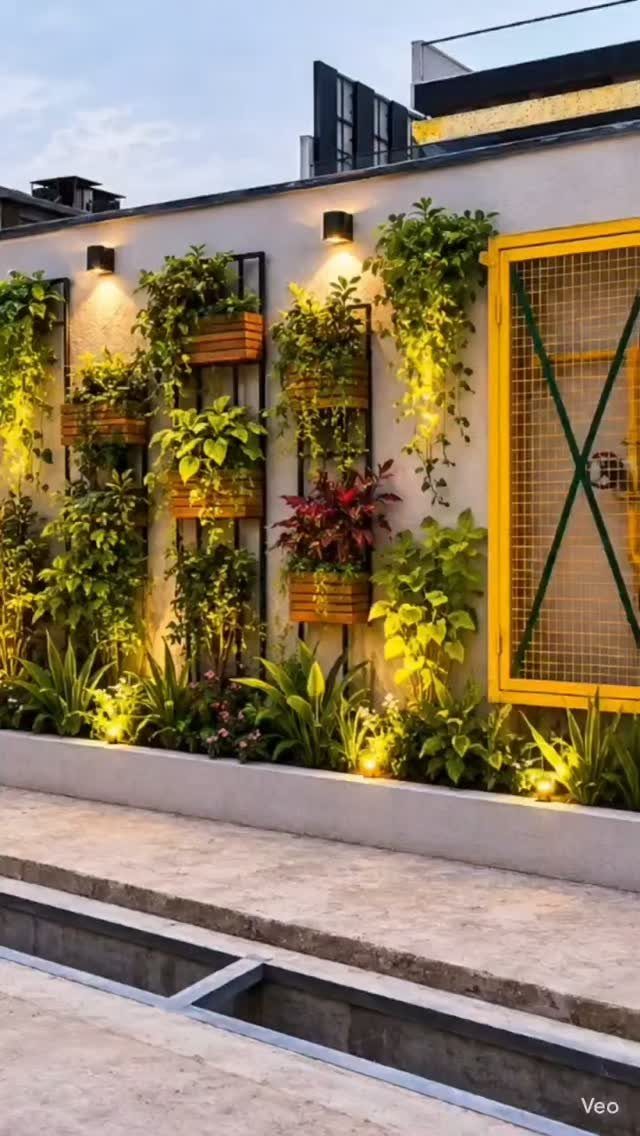 Wooden planter boxes with lush green plants mounted vertically on a white outdoor wall.