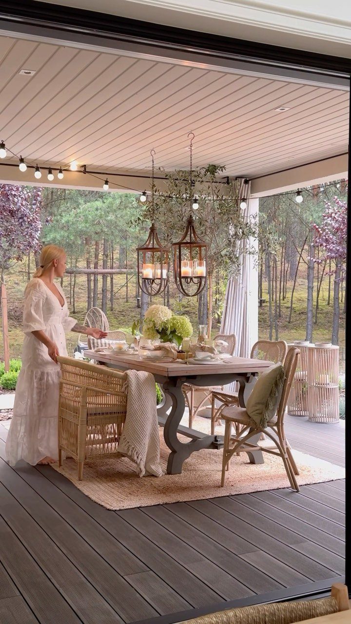 Easy Patio Table DIY: 8 Projects for Your Yard 5 A large farmhouse style wooden dining table set for a meal on a covered outdoor patio.