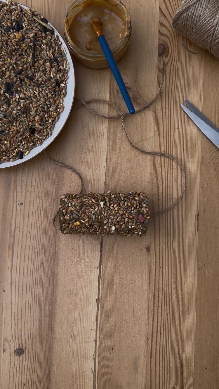 21 Home Decor Ideas for Garden Spaces That Work in Any Yard 15 A handmade seed bird feeder with twine on a wooden table next to birdseed and peanut butter.
