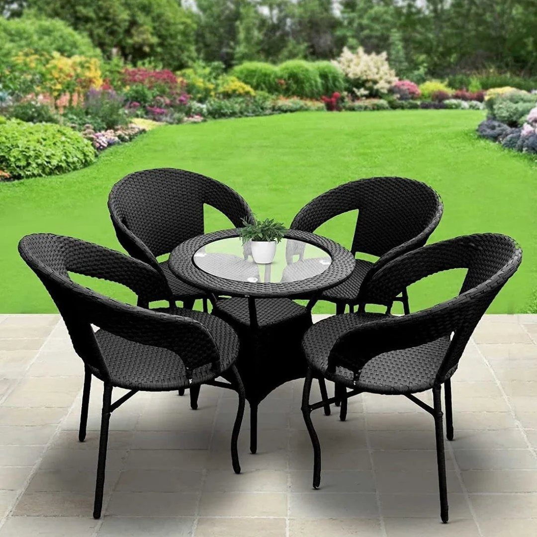 21 Home Decor Ideas for Garden Spaces That Work in Any Yard 9 Black wicker patio furniture set with a glass table and four chairs on a stone terrace.