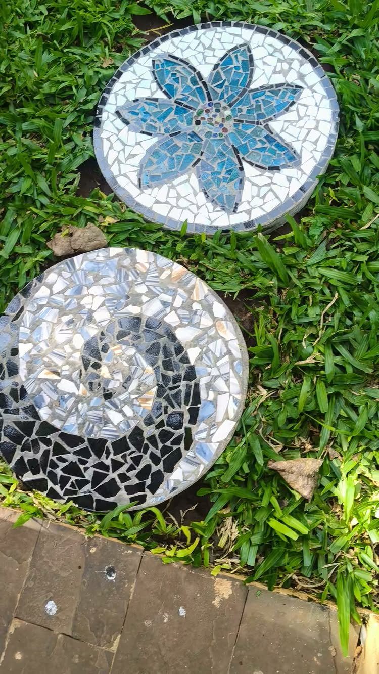 21 Home Decor Ideas for Garden Spaces That Work in Any Yard 1 Two circular mosaic stepping stones with floral and swirl patterns resting on green grass.