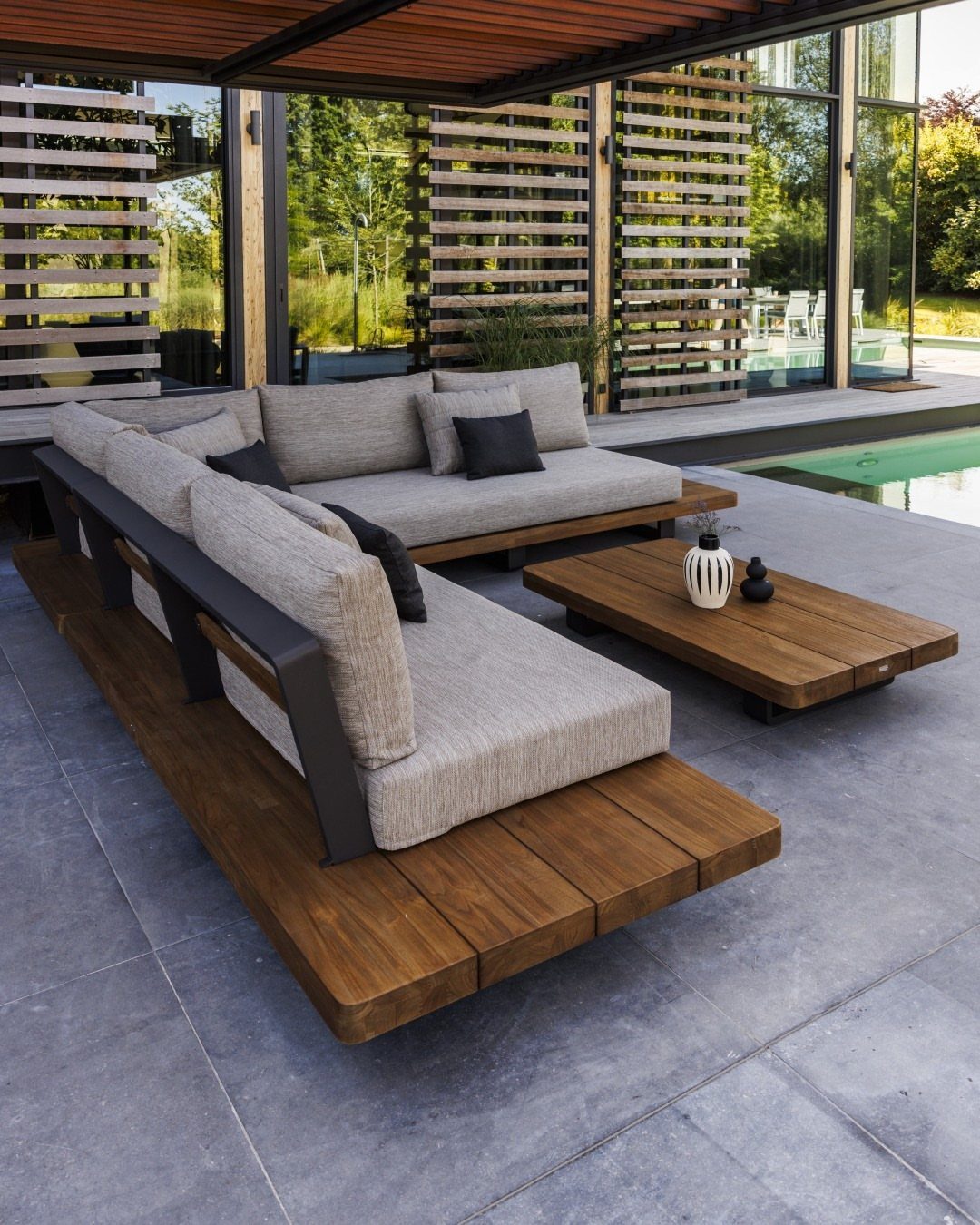 Pool Deck Ideas: 20 Designs From Breeze Blocks to Mountain Views 2 Modular light-wood sectional sofa with grey cushions sits on a tiled patio by a pool.