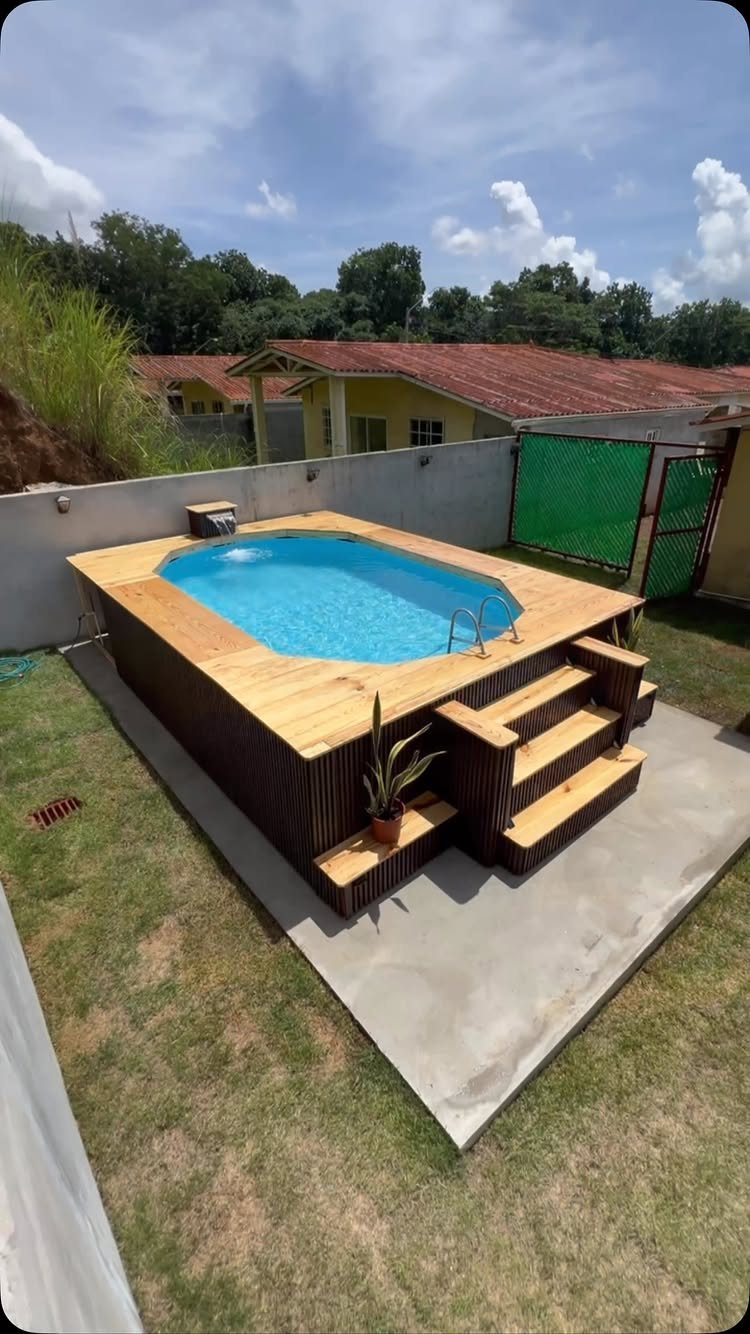 Pool Deck Ideas: 20 Designs From Breeze Blocks to Mountain Views 17 A small blue swimming pool surrounded by a light wooden deck with built-in steps.
