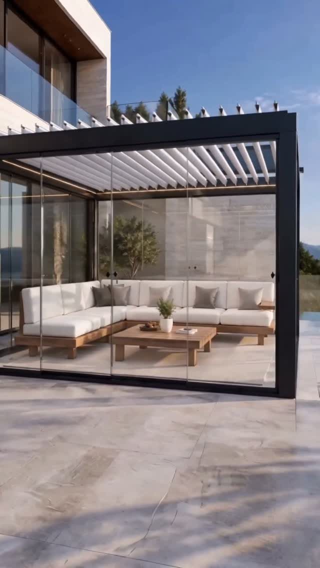 Pool Deck Ideas: 20 Designs From Breeze Blocks to Mountain Views 6 Modern glass-walled lounge featuring white sectional seating and a wooden coffee table on a stone patio.