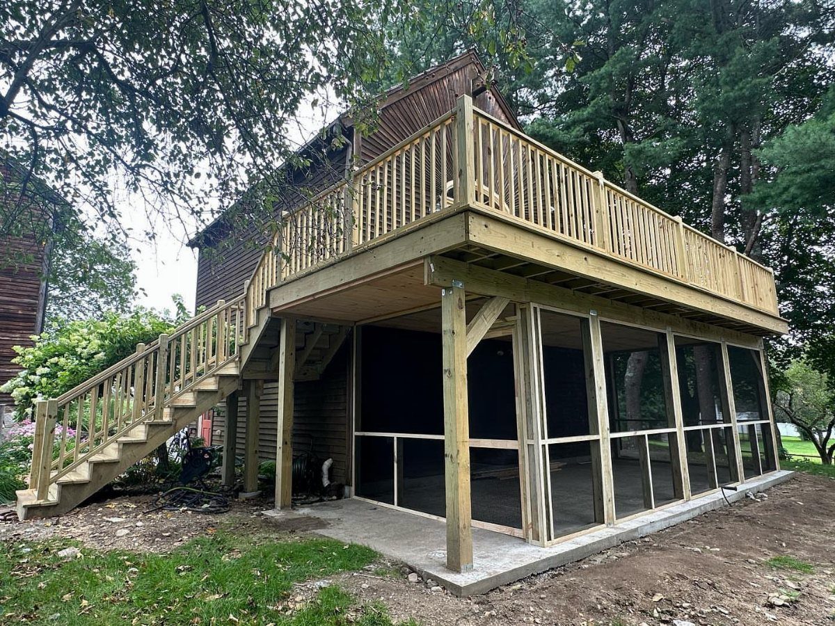 Wooden deck with a newly constructed screened-in porch area underneath the structure.